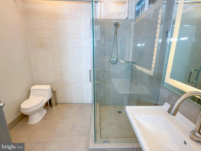 bathroom featuring sink, tile patterned flooring, a shower with door, and toilet