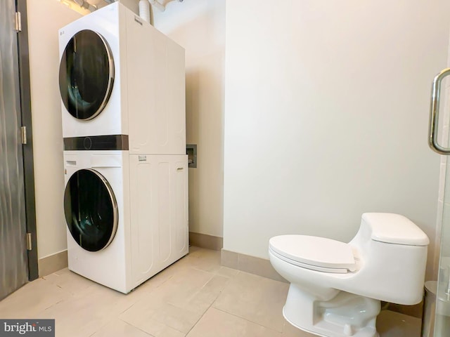 washroom with light tile patterned flooring and stacked washer / drying machine