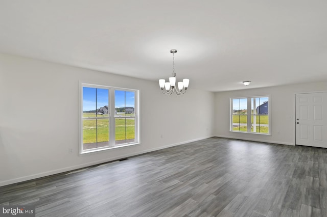 interior space with dark wood-type flooring, baseboards, and an inviting chandelier