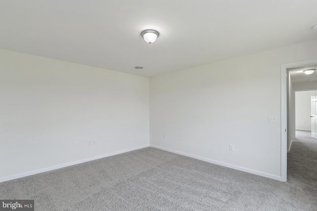 carpeted empty room with visible vents and baseboards