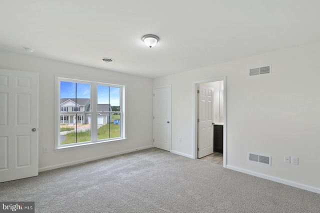 unfurnished bedroom with carpet, visible vents, and baseboards