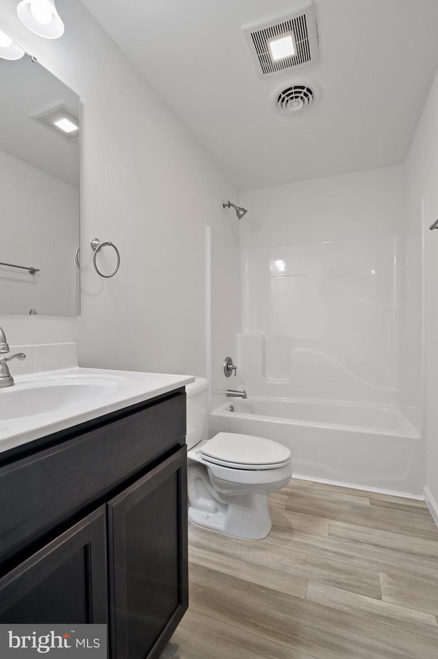 full bathroom with toilet, tub / shower combination, hardwood / wood-style flooring, and vanity