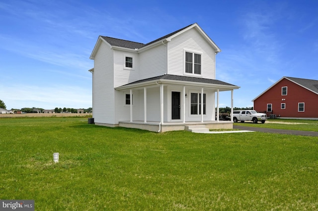 rear view of property featuring a lawn and a porch