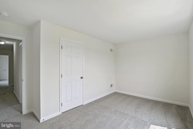 unfurnished bedroom featuring visible vents, baseboards, and light colored carpet