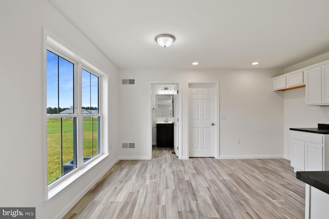 interior space featuring baseboards, visible vents, light wood-style flooring, and recessed lighting