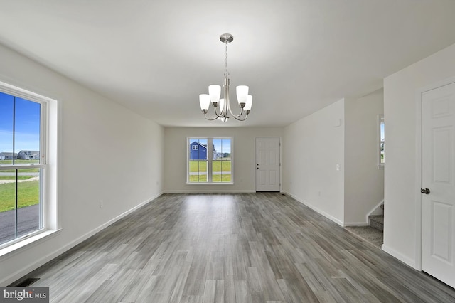 empty room featuring hardwood / wood-style floors and an inviting chandelier