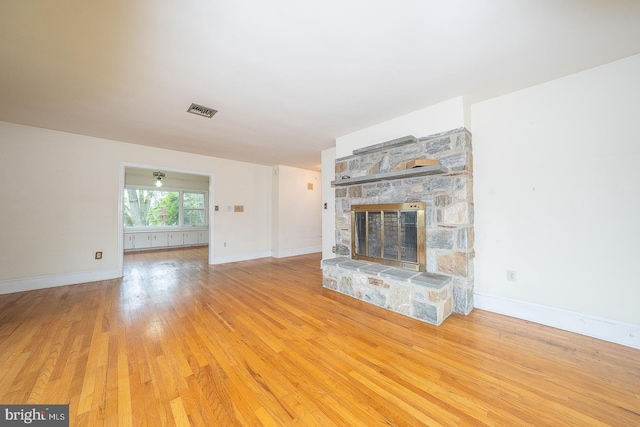 unfurnished living room with a fireplace and light wood-type flooring