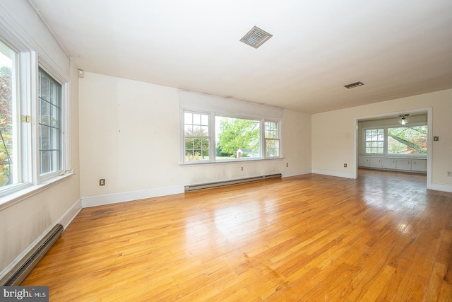 empty room featuring light hardwood / wood-style flooring, ceiling fan, and baseboard heating