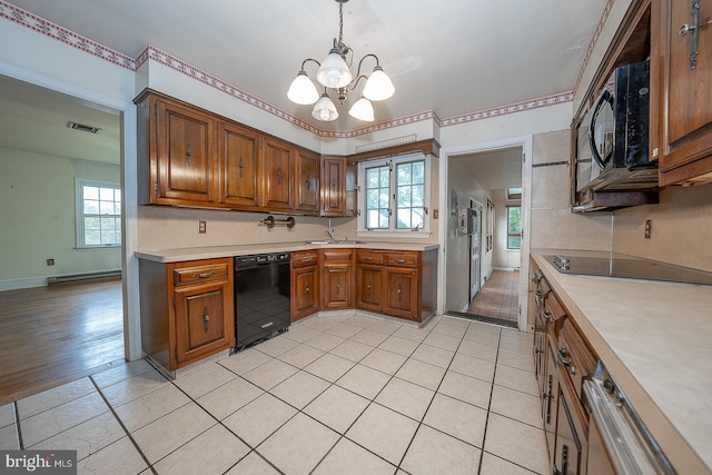 kitchen featuring sink, decorative light fixtures, black appliances, a notable chandelier, and light hardwood / wood-style floors