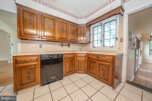 kitchen with black dishwasher, light tile patterned floors, and sink