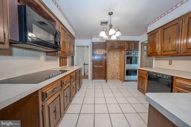 kitchen featuring black appliances, light tile patterned floors, pendant lighting, and a chandelier