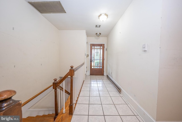 hallway with a baseboard radiator and light tile patterned flooring