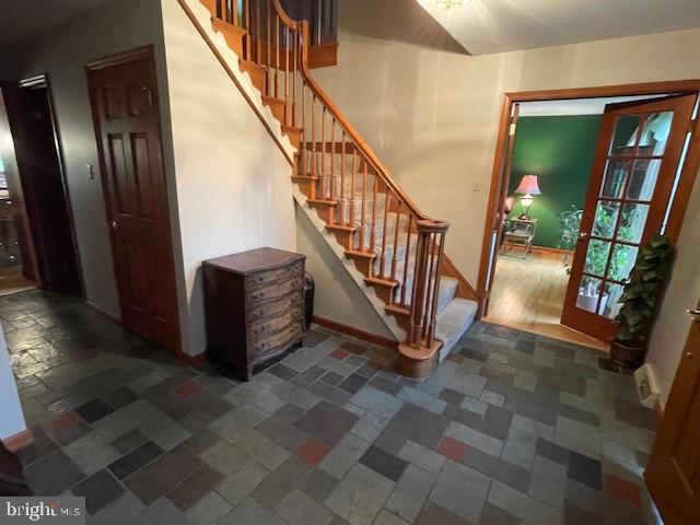 stairs with baseboards and stone tile flooring