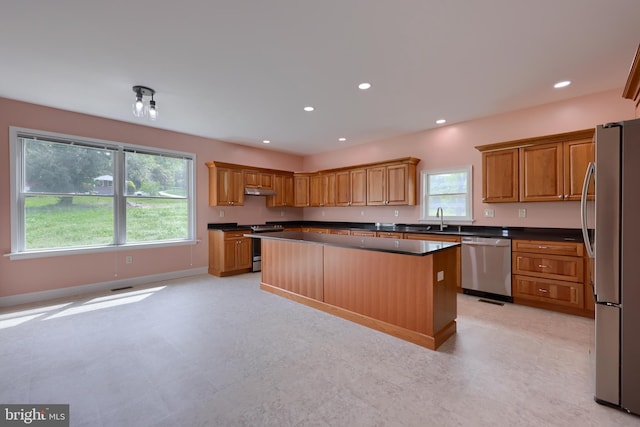 kitchen featuring appliances with stainless steel finishes, a center island, and sink