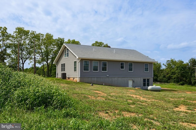 view of side of property featuring a lawn and central AC unit