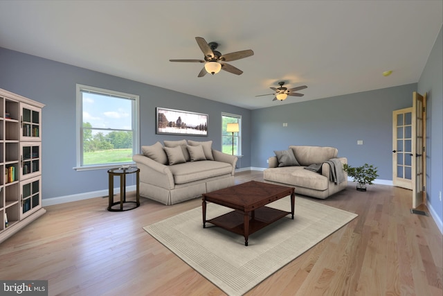 living room featuring plenty of natural light, ceiling fan, and light hardwood / wood-style flooring