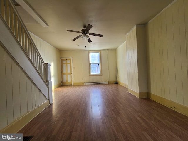 unfurnished living room with ceiling fan, wood walls, dark hardwood / wood-style flooring, and a baseboard radiator