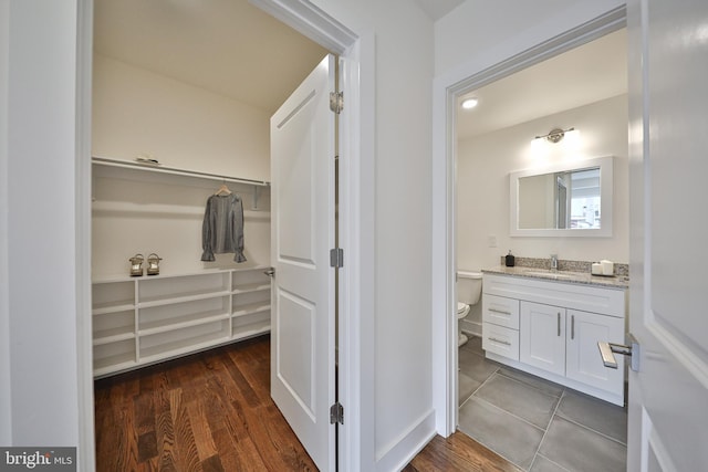 bathroom with vanity, toilet, and hardwood / wood-style flooring