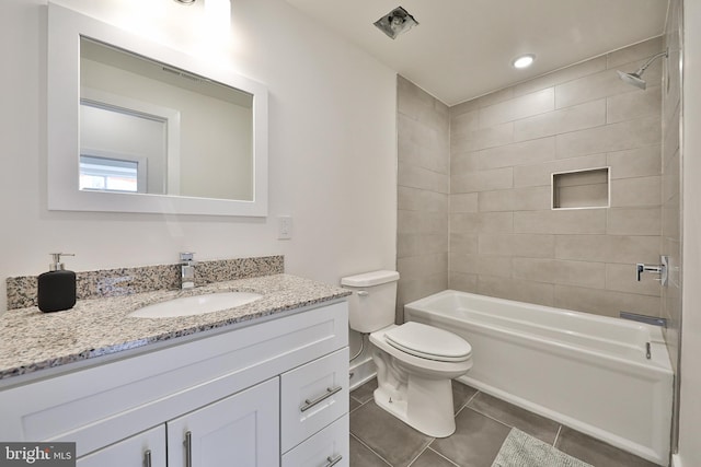 full bathroom featuring tile patterned flooring, toilet, tiled shower / bath combo, and vanity