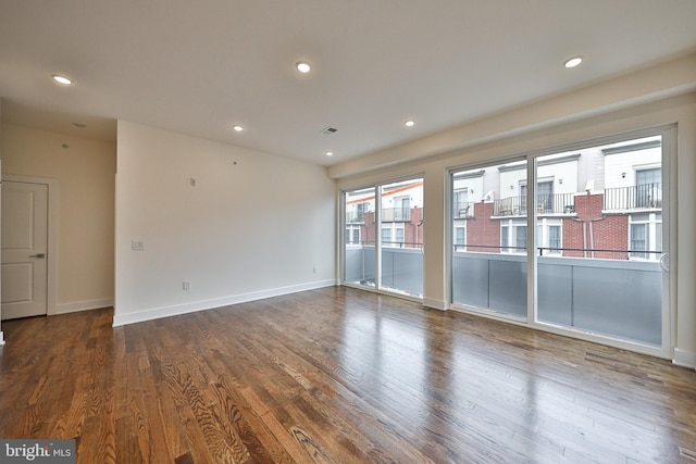 empty room with a wealth of natural light and wood-type flooring