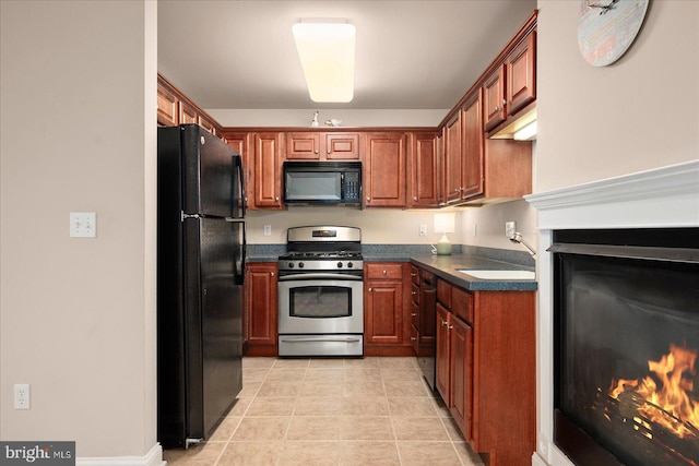 kitchen featuring black appliances, sink, and light tile patterned flooring