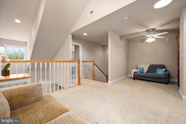 living area featuring lofted ceiling, ceiling fan, and light carpet