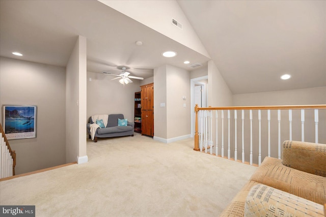 living area featuring ceiling fan, light carpet, and vaulted ceiling