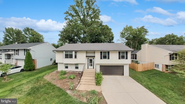 split foyer home featuring a garage and a front yard