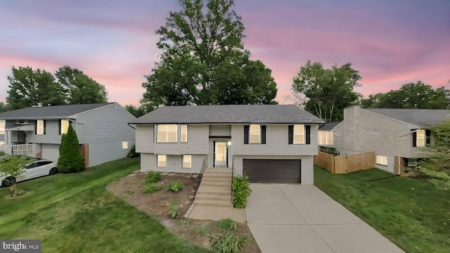 bi-level home with a lawn and a garage