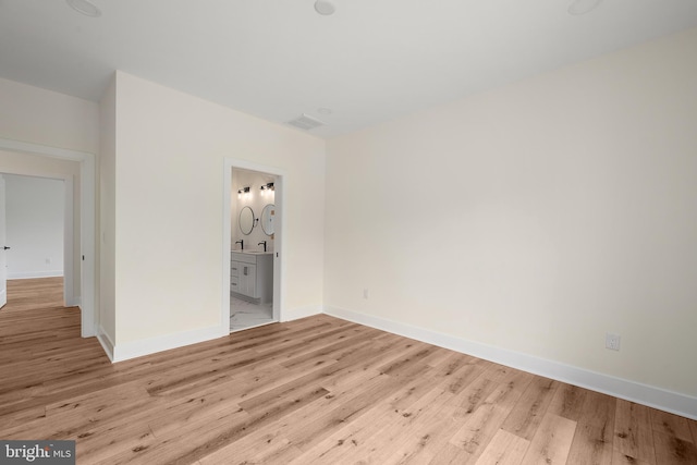 unfurnished bedroom featuring light hardwood / wood-style flooring and ensuite bath