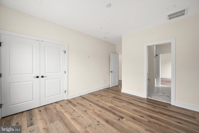 unfurnished bedroom featuring hardwood / wood-style floors and a closet