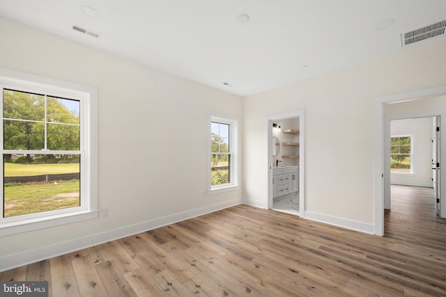 unfurnished bedroom with wood-type flooring, visible vents, and baseboards