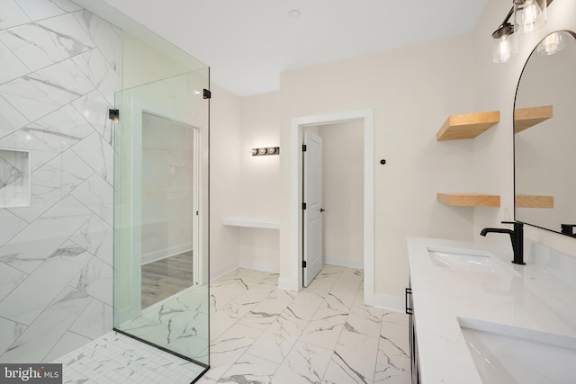 full bathroom featuring marble finish floor, a sink, a marble finish shower, and baseboards