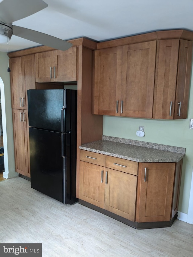 kitchen with light hardwood / wood-style flooring and black fridge