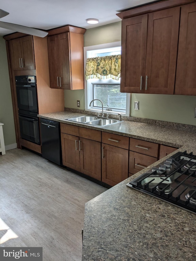 kitchen featuring black appliances, light hardwood / wood-style floors, and sink