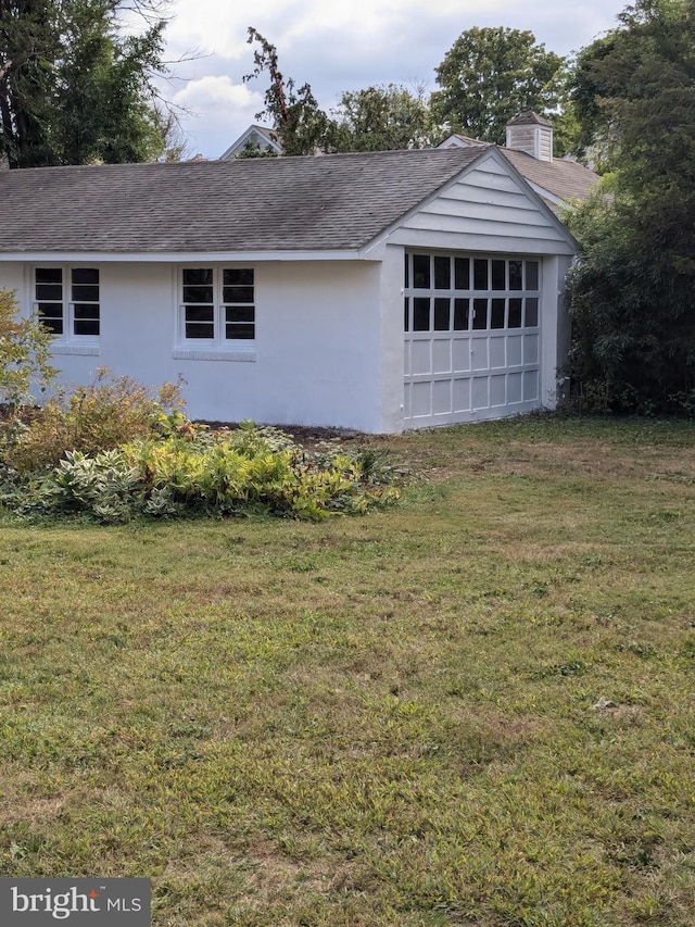 view of side of home featuring a garage and a lawn