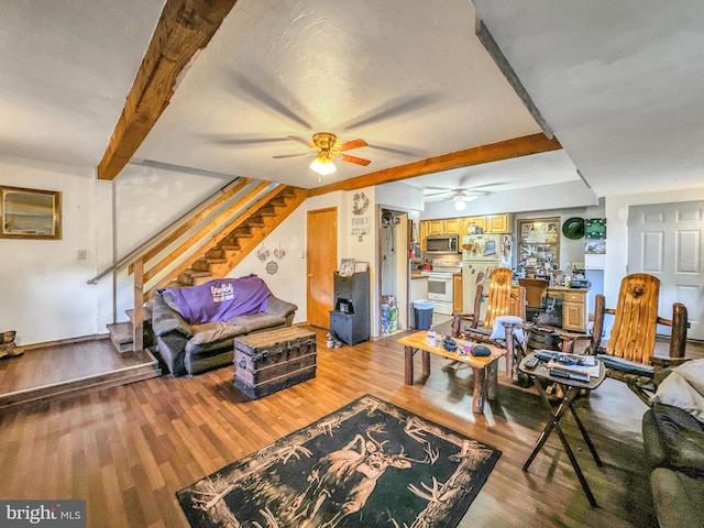 living room with a textured ceiling, ceiling fan, hardwood / wood-style floors, and beam ceiling