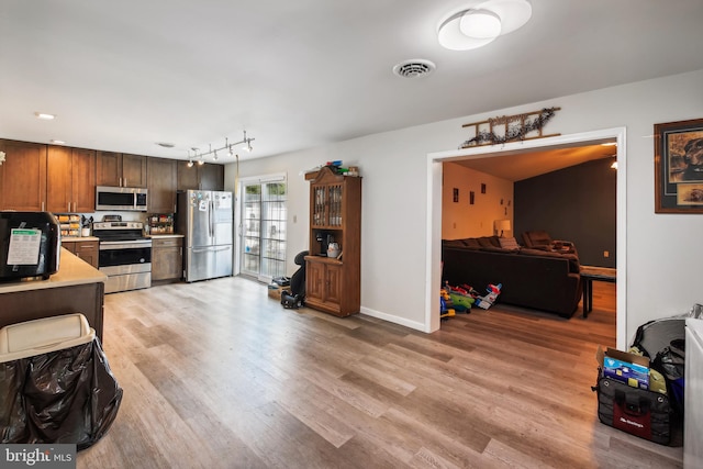 kitchen featuring stainless steel appliances and light hardwood / wood-style floors