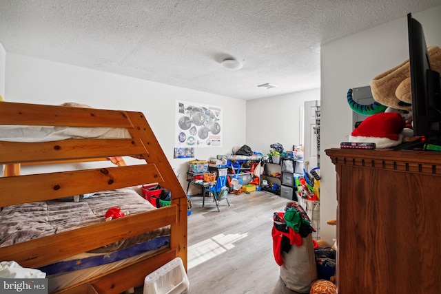 bedroom featuring a textured ceiling and light hardwood / wood-style floors