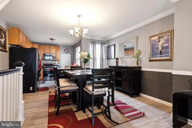 dining area featuring an inviting chandelier, light hardwood / wood-style floors, and crown molding