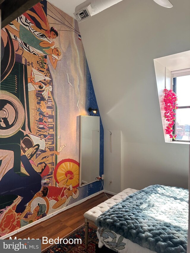 bedroom with wood-type flooring and vaulted ceiling