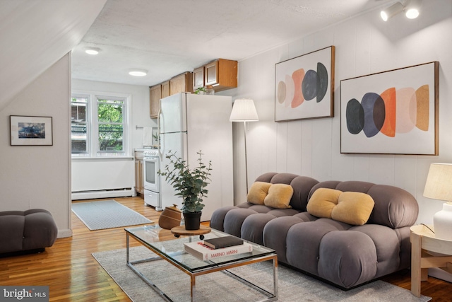 living room with light wood-style flooring and baseboard heating