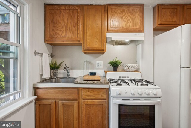 kitchen featuring white appliances and sink