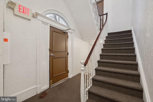 stairs featuring carpet floors and a textured wall