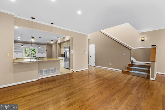 unfurnished living room with crown molding and light hardwood / wood-style flooring