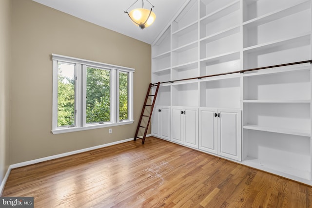 interior space featuring lofted ceiling and light hardwood / wood-style flooring