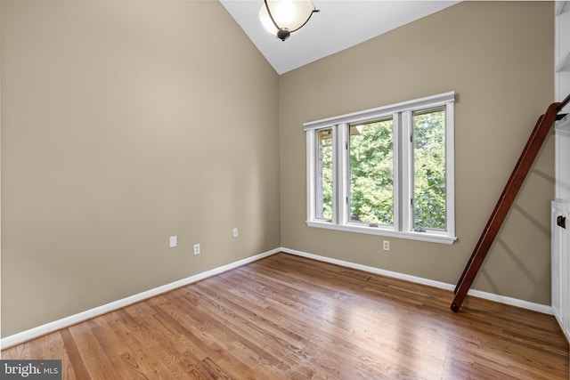 spare room featuring light hardwood / wood-style floors and vaulted ceiling