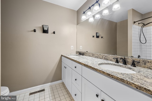 bathroom with tile patterned floors, vanity, toilet, and tiled shower