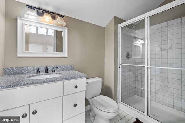 bathroom featuring tile patterned flooring, vanity, toilet, and a shower with shower door