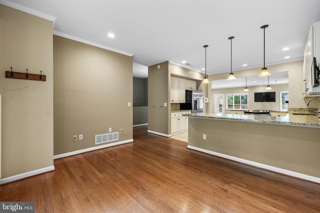 kitchen featuring kitchen peninsula, stainless steel refrigerator with ice dispenser, light stone countertops, white cabinets, and light hardwood / wood-style floors